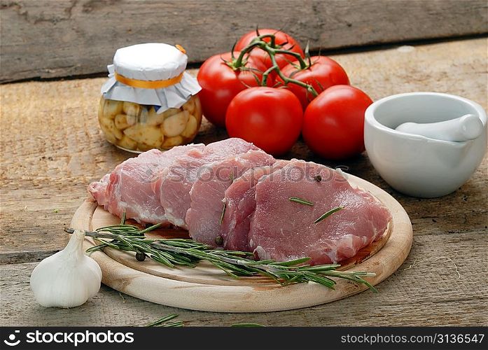 raw meat with rosemary, garlic and porcelain mortar