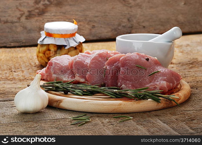 raw meat with rosemary, garlic and porcelain mortar