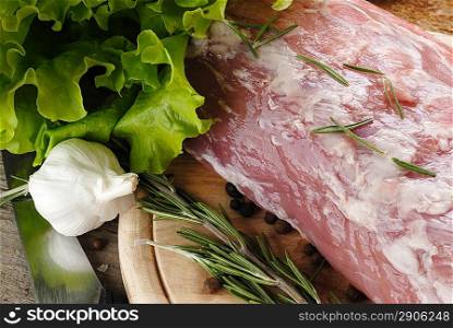 raw meat with rosemary, garlic, lettuce