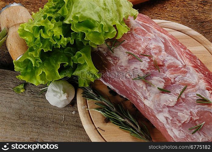 raw meat with rosemary, garlic, lettuce