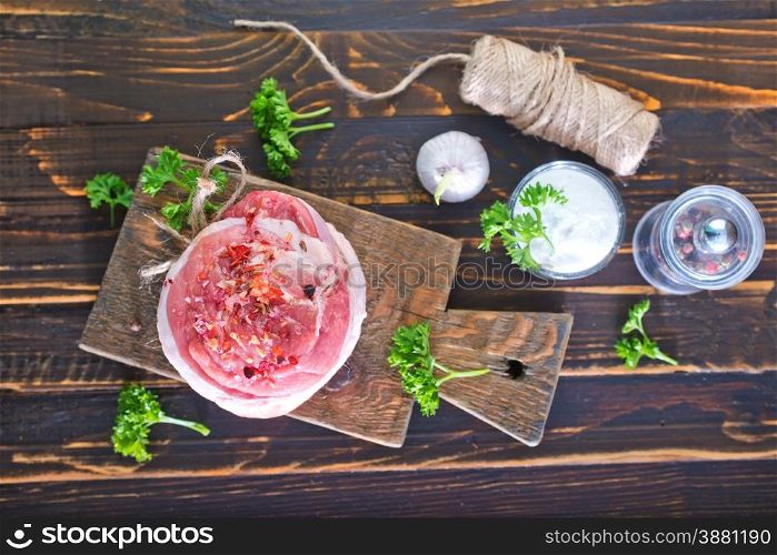 raw meat with salt and spice on the wooden board
