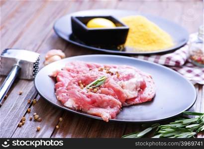 raw meat with spice on plate and on a table