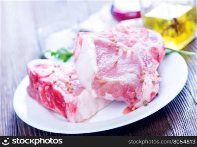 raw meat with spice on white plate and on a table
