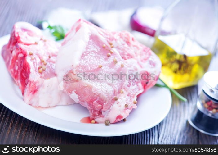 raw meat with spice on white plate and on a table