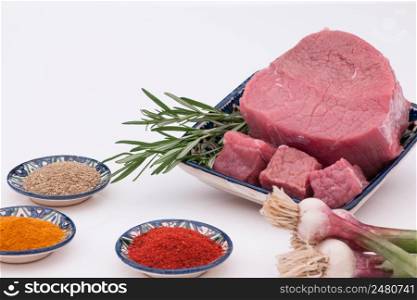 raw meat with spices and onions on a white background. raw meat with spices