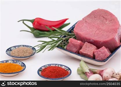 raw meat with spices and onions on a white background. raw meat with spices