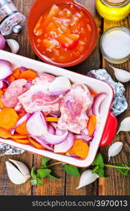 raw meat with vegetables in the bowl and on a table