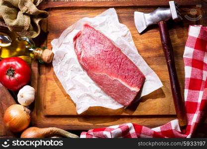 raw meat with vegetables on wooden board