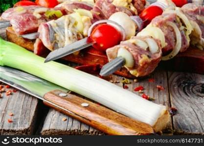 raw meat with vegetables threaded onto a skewer for roasting on the coals. raw meat on skewer