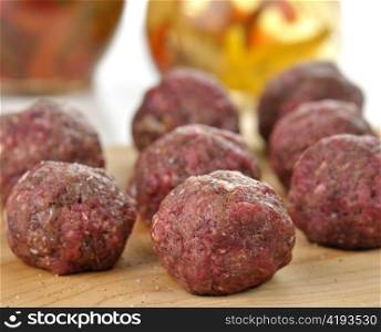 raw meatballs on a cutting board , close up