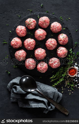 Raw meatballs on dark background, top view