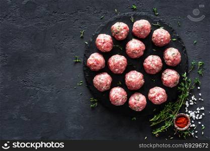 Raw meatballs on dark background, top view