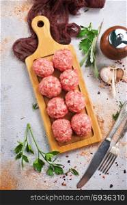 raw meatballs with aroma spice and on a table