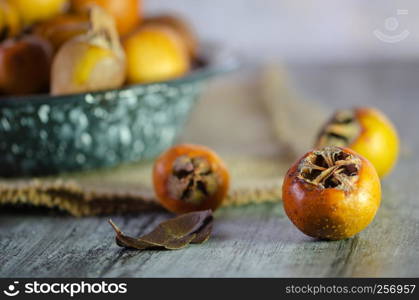 Raw medlars on a rustic wooden table top view