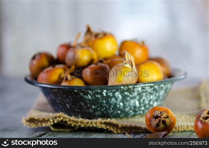 Raw medlars on a rustic wooden table top view