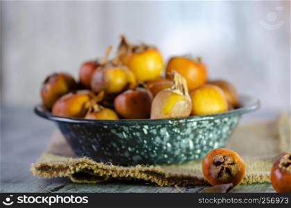 Raw medlars on a rustic wooden table top view