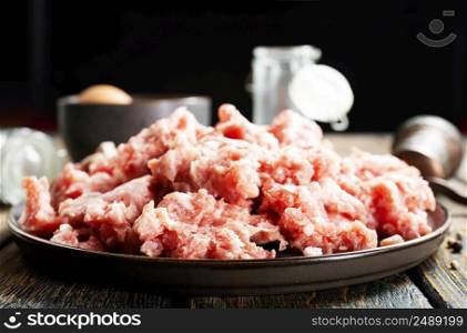 Raw mince lamb, ground mutton meat with herbs on a plate. Top view.. Raw mince lamb, ground mutton meat with herbs on a plate.