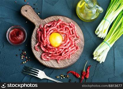 raw minced meat on plate and on a table