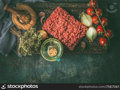 Raw minced meat with cooking ingredients for cooking on rustic background. Top view. Border