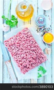 raw minced meat with spice and salt on a table