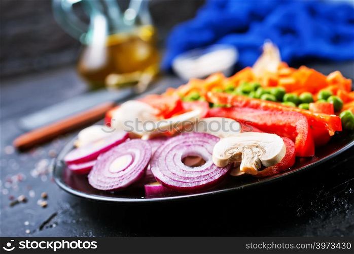 raw mushroom and fresh vegetables on plate on a table
