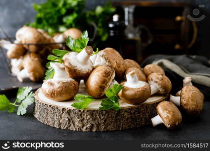 Raw mushrooms champignons on black background, cooking fresh champignons