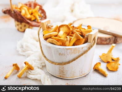 raw mushrooms in white wooden bowl and on a table