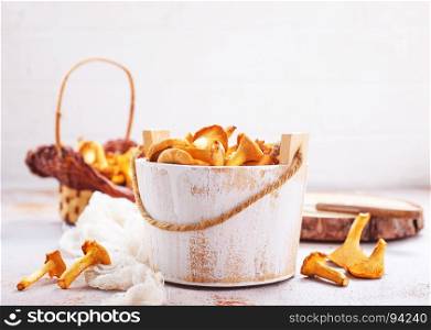 raw mushrooms in white wooden bowl and on a table