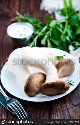 raw mushrooms on plate and on a table
