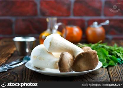 raw mushrooms on plate and on a table