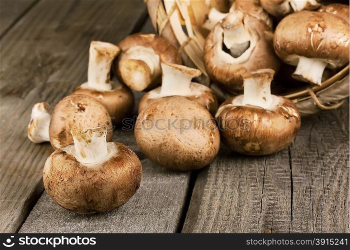 Raw mushrooms with brown hat on a wooden background