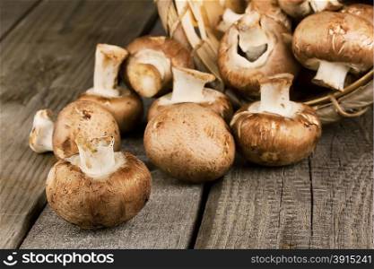 Raw mushrooms with brown hat on a wooden background