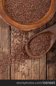 Raw natural organic linseed flax-seed in wooden spoon on wood background. Healthy omega 3 product.