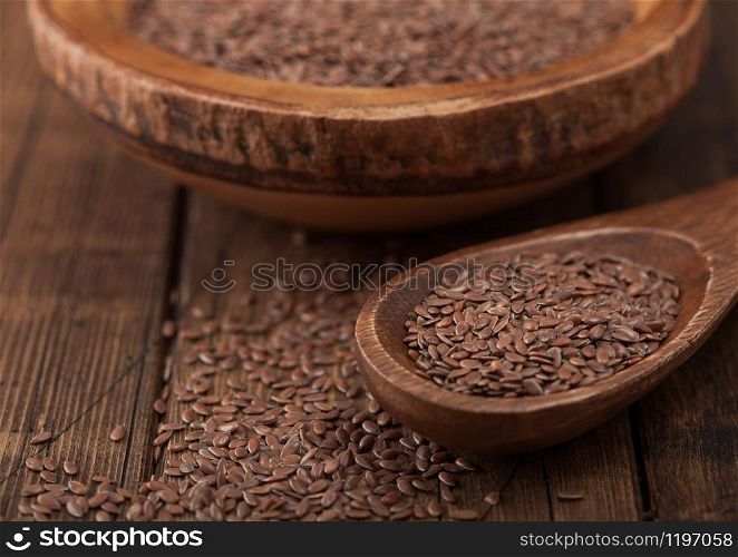 Raw natural organic linseed flax-seed in wooden spoon on wood background.Macro