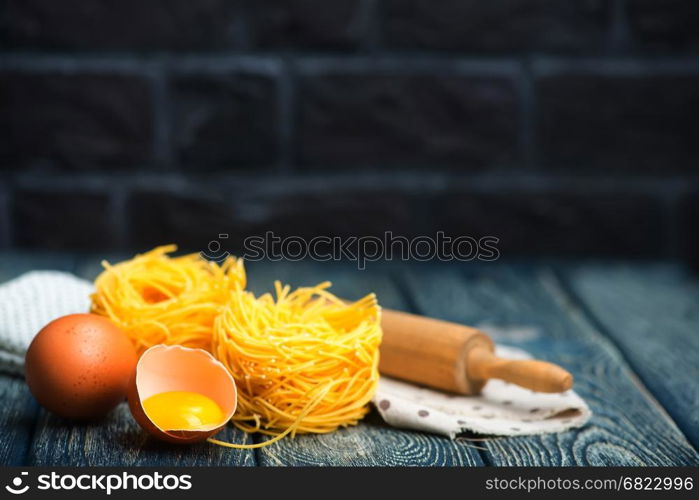 raw noodles with chicken yolks on a table