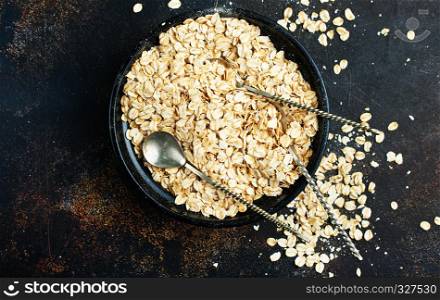 raw oat flakes in bowl on a table