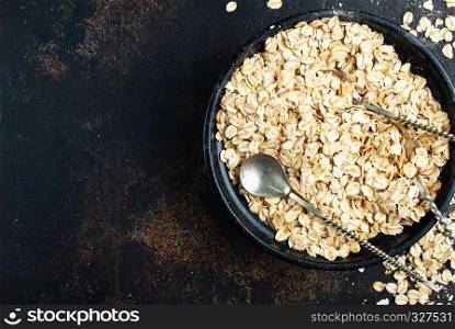 raw oat flakes in bowl on a table