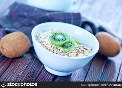 raw oat flakes in the white bowl