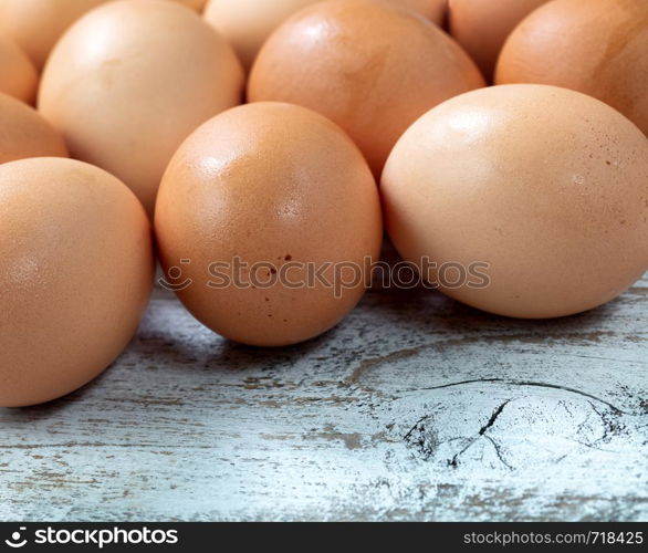 Raw organic brown farm eggs on white rustic wooded background