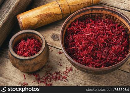 Raw organic red saffron spice on wooden background. Dried saffron spice