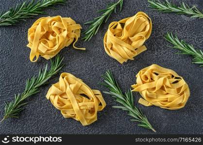 Raw pappardelle - flat Italian pasta noodles with fresh rosemary