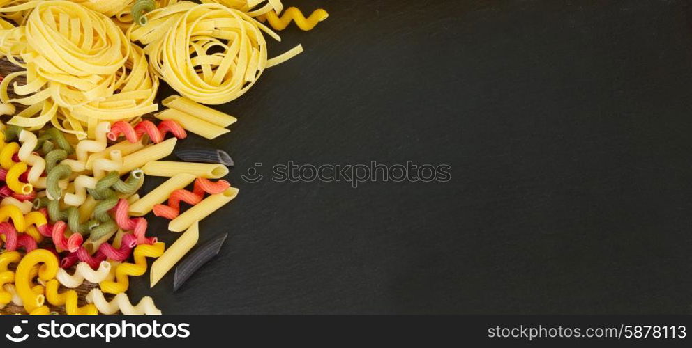 Raw pasta . Raw pasta with copy space on black board