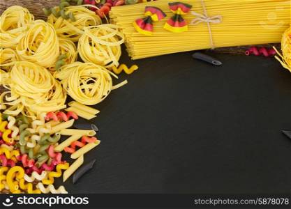 Raw pasta . Raw pasta with copy space on black cutting board