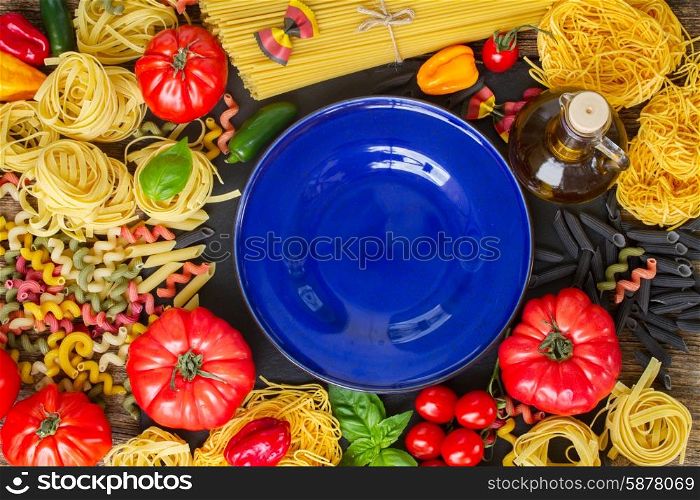 Raw pasta with ingridients and blue plate. Raw pasta with ingridients and copy space on blue plate