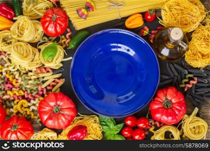 Raw pasta with ingridients and blue plate. Raw pasta with ingridients and copy space on blue plate