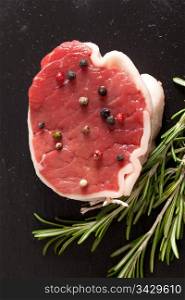 Raw piece of beef with rosemary