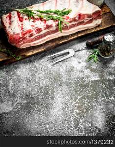 Raw pig ribs with herbs and spices. On rustic background.. Raw pig ribs with herbs and spices.