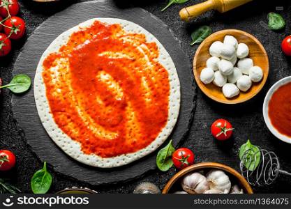 Raw pizza. Dough with different ingredients for pizza. Top view. Raw pizza. Dough with different ingredients for pizza.