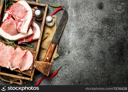 Raw pork meat with herbs and spices in a tray. On rustic background.. Raw pork meat with herbs and spices in a tray.