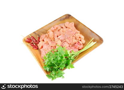raw pork meat with red pepper and parsley ready to be cooked on a wooden tray (over white)